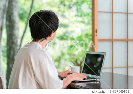 ワーケーション,リモートワークをするアドレスホッパーの若い男性 141798491