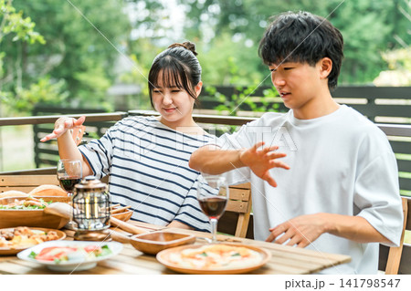 アウトドアで食事中に虫刺されで困っているカップル アウトドアで食事中に虫刺されで困っているカップル 141798547