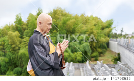 霊園にて静かに祈りを捧げる僧侶の横顔 霊園にて静かに祈りを捧げる僧侶の横顔 141798633