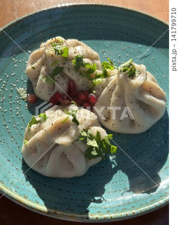 Steamed xiaolongbao dumplings with delicate thin skin, slightly translucent top folds, and savory soup filling inside, highlighting their soft texture and freshly steamed appearance in close-up detail Steamed xiaolongbao dumplings with delicate thin skin, slightly translucent top folds, and savory soup filling inside, highlighting their soft texture and freshly steamed appearance in close-up detail 141799710