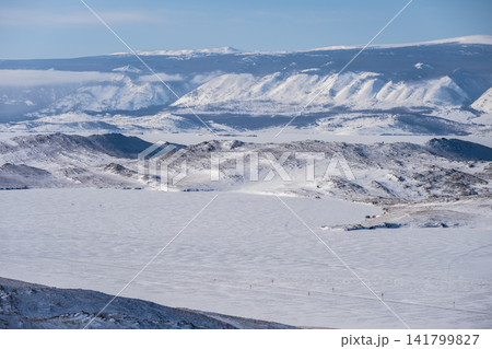 Scenery view of frozen lake Baikal in winter season, the surface of lake covered by snow. Lake Baikal is the world's deepest lake located in southern Siberia, Russia. Scenery view of frozen lake Baikal in winter season, the surface of lake covered by snow. Lake Baikal is the world's deepest lake located in southern Siberia, Russia. 141799827