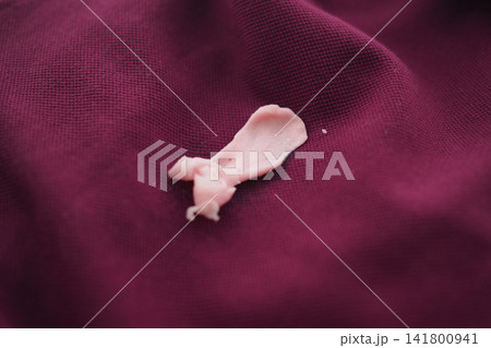 Old piece of gum on purple fabric 141800941