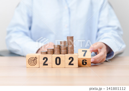 2026 end year to Happy New Year 2027 with Coins stack and dartboard icon. Strategy, goal, Money, Budget, tax, investment, financial, savings and New Year Resolution concepts 141801112