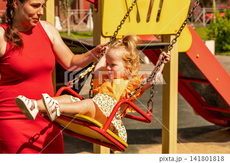 Smiling Toddler Girl Enjoying Swing With Her Mother 141801818
