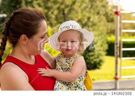 Mother Holds Toddler Daughter Wearing Sun Hat Outdoors Mother Holds Toddler Daughter Wearing Sun Hat Outdoors 141802308