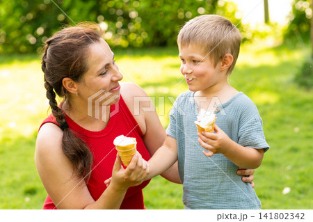 Mother and Son Enjoying Ice Cream Together in Park Mother and Son Enjoying Ice Cream Together in Park 141802342