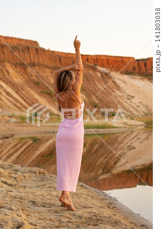 Barefoot Woman Stretching Arms In Rocky Lakeside Landscape Barefoot Woman Stretching Arms In Rocky Lakeside Landscape 141803038