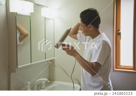 洗面所でドライヤーをかける40代男性のヘアドライ 洗面所でドライヤーをかける40代男性のヘアドライ 141803123