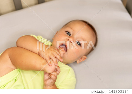 Baby Boy Bringing Bare Foot Toward Mouth At Home Baby Boy Bringing Bare Foot Toward Mouth At Home 141803154