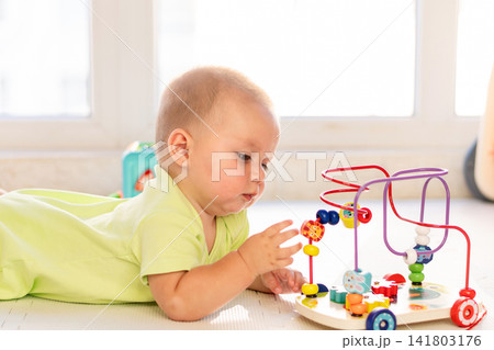 Baby Boy Reaches For Beads On Educational Maze Toy 141803176