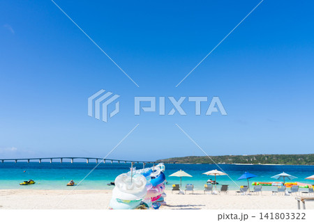 澄み渡る青空と白い砂浜のビーチパラソルとマリンアクティビティ 澄み渡る青空と白い砂浜のビーチパラソルとマリンアクティビティ 141803322