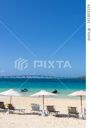 澄み渡る青空と白い砂浜のビーチパラソルとマリンアクティビティ 澄み渡る青空と白い砂浜のビーチパラソルとマリンアクティビティ 141803324