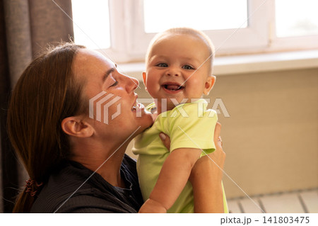 Baby Boy Touches Mother Chin During Playful Window Moment Baby Boy Touches Mother Chin During Playful Window Moment 141803475