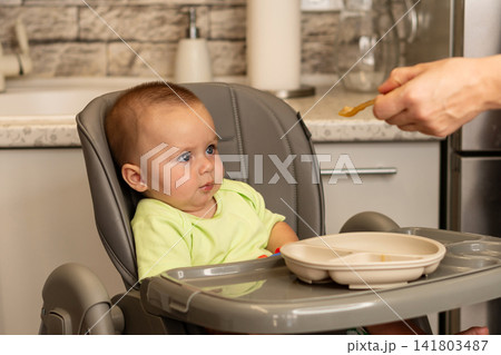 Baby Boy Touches Mother Chin During Playful Window Moment 141803487