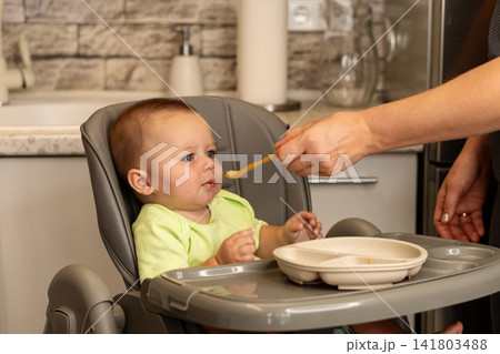 Baby Boy Touches Mother Chin During Playful Window Moment 141803488