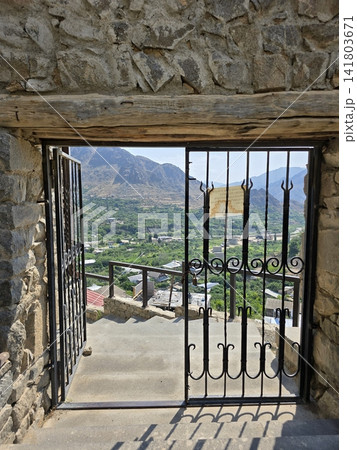 View through stone archway gate, mountains and valley below 141803671