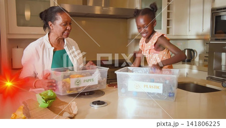 Sorting gran, grandchild placing into PAPER or PLASTIC bins in kitchen in white top and peach dress Sorting gran, grandchild placing into PAPER or PLASTIC bins in kitchen in white top and peach dress 141806225