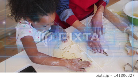 Pressing cookie cutters, woman red top guiding child white shirt on flour-dusted counter with phone 141806327