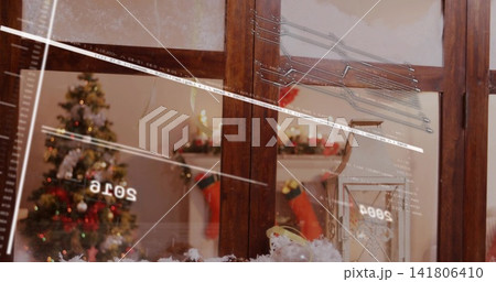 Framing wooden window panes showing cozy living room with tree, stockings, reflections, faux snow 141806410