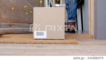 Sitting parcel with barcode on coir doormat at front porch, confetti near rolled jeans and boots Sitting parcel with barcode on coir doormat at front porch, confetti near rolled jeans and boots 141806474