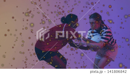Competing women in studio in red shirt and striped top, contesting white ball with golden confetti Competing women in studio in red shirt and striped top, contesting white ball with golden confetti 141806842