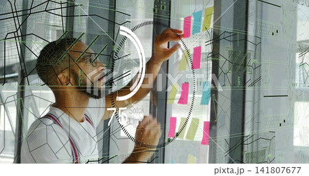 Arranging man in red-strapped T-shirt placing colorful notes on glass in office, with HUD graphics Arranging man in red-strapped T-shirt placing colorful notes on glass in office, with HUD graphics 141807677