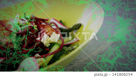 Showing yellow bowl with asparagus, cucumber, feta, red spirals on gray counter, green overlay 141808254