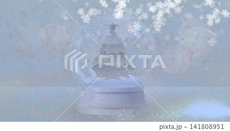 Showing frosted glass snow globe sitting on flat tabletop, with tiered tree, star, snowflakes Showing frosted glass snow globe sitting on flat tabletop, with tiered tree, star, snowflakes 141808951