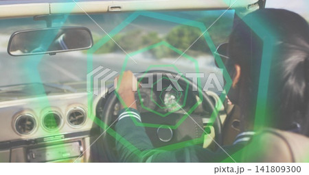 Driving Indian woman in dark jacket gripping steering wheel in RHD car, green overlay, copy space Driving Indian woman in dark jacket gripping steering wheel in RHD car, green overlay, copy space 141809300