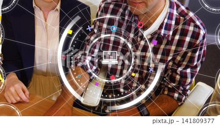 Leaning man in plaid shirt studying HUD at meeting table with wooden surface, laptop icon Leaning man in plaid shirt studying HUD at meeting table with wooden surface, laptop icon 141809377