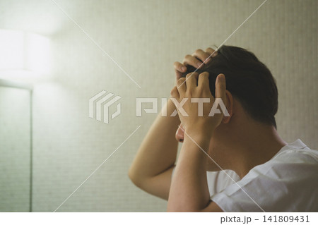 洗面台で分け目の薄毛を気にして頭を触る40代男性のヘアトラブル 洗面台で分け目の薄毛を気にして頭を触る40代男性のヘアトラブル 141809431