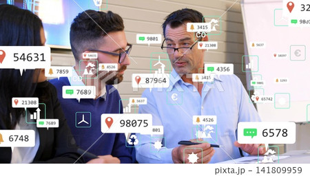 Discussing colleagues studying AR overlays at meeting table in business attire, holding smartphone 141809959