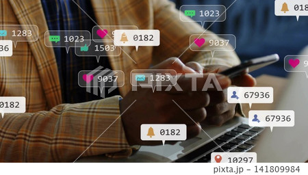 Scrolling man in tan plaid blazer blue shirt using smartphone above laptop at desk, floating badges 141809984