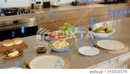Displaying kitchen island countertop offering place settings, fries, burger buns, salad at home Displaying kitchen island countertop offering place settings, fries, burger buns, salad at home 141810170