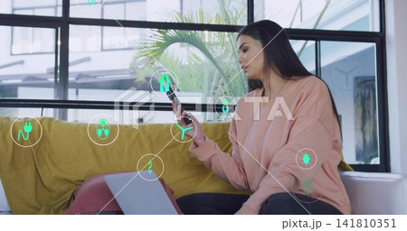 Checking smartphone, woman in pink sweatshirt scrolling on laptop on lap, AR icons, copy space Checking smartphone, woman in pink sweatshirt scrolling on laptop on lap, AR icons, copy space 141810351