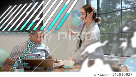 Two adults exchanging dessert at wood table, man striped shirt, woman cardigan, laptop, AR overlays 141810927