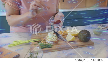 Sprinkling cook in pink lace top seasoning egg-cheese toast at kitchen counter, wooden board Sprinkling cook in pink lace top seasoning egg-cheese toast at kitchen counter, wooden board 141810928