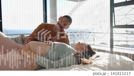 Smiling partner leaning over pregnant woman in green top, placing hand on belly on bed, overlays Smiling partner leaning over pregnant woman in green top, placing hand on belly on bed, overlays 141811217