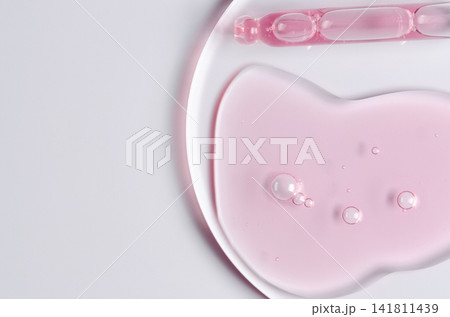 Pink cosmetic product for skin care. A serum or body gel or a moisturizer. Copy space 141811439