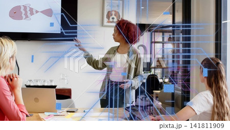 Presenting woman in olive-top gesturing toward monitor cartoon-fish in conference-room AR-overlay Presenting woman in olive-top gesturing toward monitor cartoon-fish in conference-room AR-overlay 141811909