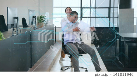 Pushing woman coworker moving seated man on rolling chair down aisle with papers, biz-casual HUD Pushing woman coworker moving seated man on rolling chair down aisle with papers, biz-casual HUD 141811946