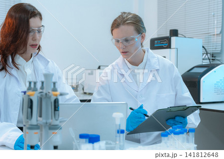 Scientist researching plant extracts for antiviral and virus prevention. Scientist researching plant extracts for antiviral and virus prevention. 141812648