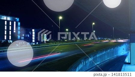 Capturing elevated ramp and highway at night creating red and white light trails, blue-lit building 141813511