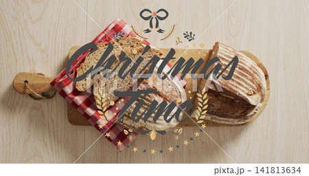 Showing two sourdough loaves, one partially sliced on paddleboard at home Christmas Time overlay 141813634