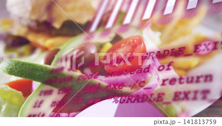 Showing salad sitting on table with halved tomato, onion rings, avocado and magenta code overlay 141813759