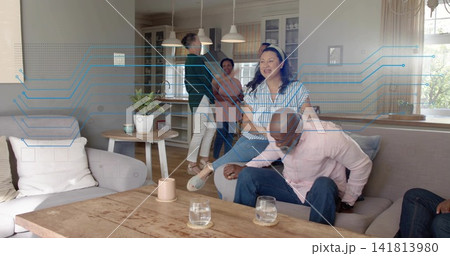 Smiling woman in striped blouse sitting on sofa arm, chatting in open home with blue overlay 141813980
