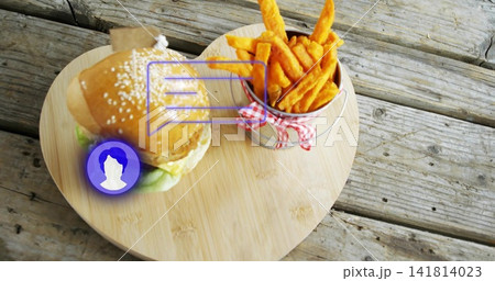 Showing sesame-seed burger, flag and fries cup on heart board at worn picnic table, purple overlay Showing sesame-seed burger, flag and fries cup on heart board at worn picnic table, purple overlay 141814023
