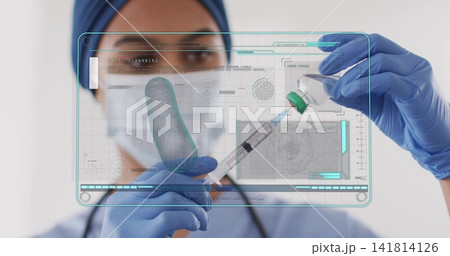 Nurse in surgical cap, mask, blue gloves drawing vaccine into syringe in clinic, hologram Nurse in surgical cap, mask, blue gloves drawing vaccine into syringe in clinic, hologram 141814126