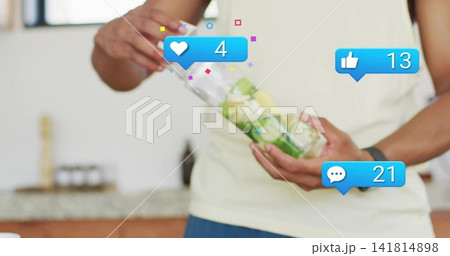 Preparing torso,hands filling cucumber bottle in kitchen, in beige tee blue shorts, 3 blue bubbles 141814898