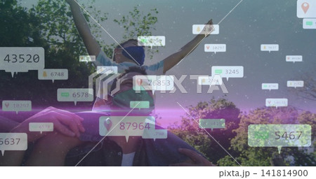 Carrying father supporting son on shoulders, raising arms in park, with cloth mask, UI overlays Carrying father supporting son on shoulders, raising arms in park, with cloth mask, UI overlays 141814900